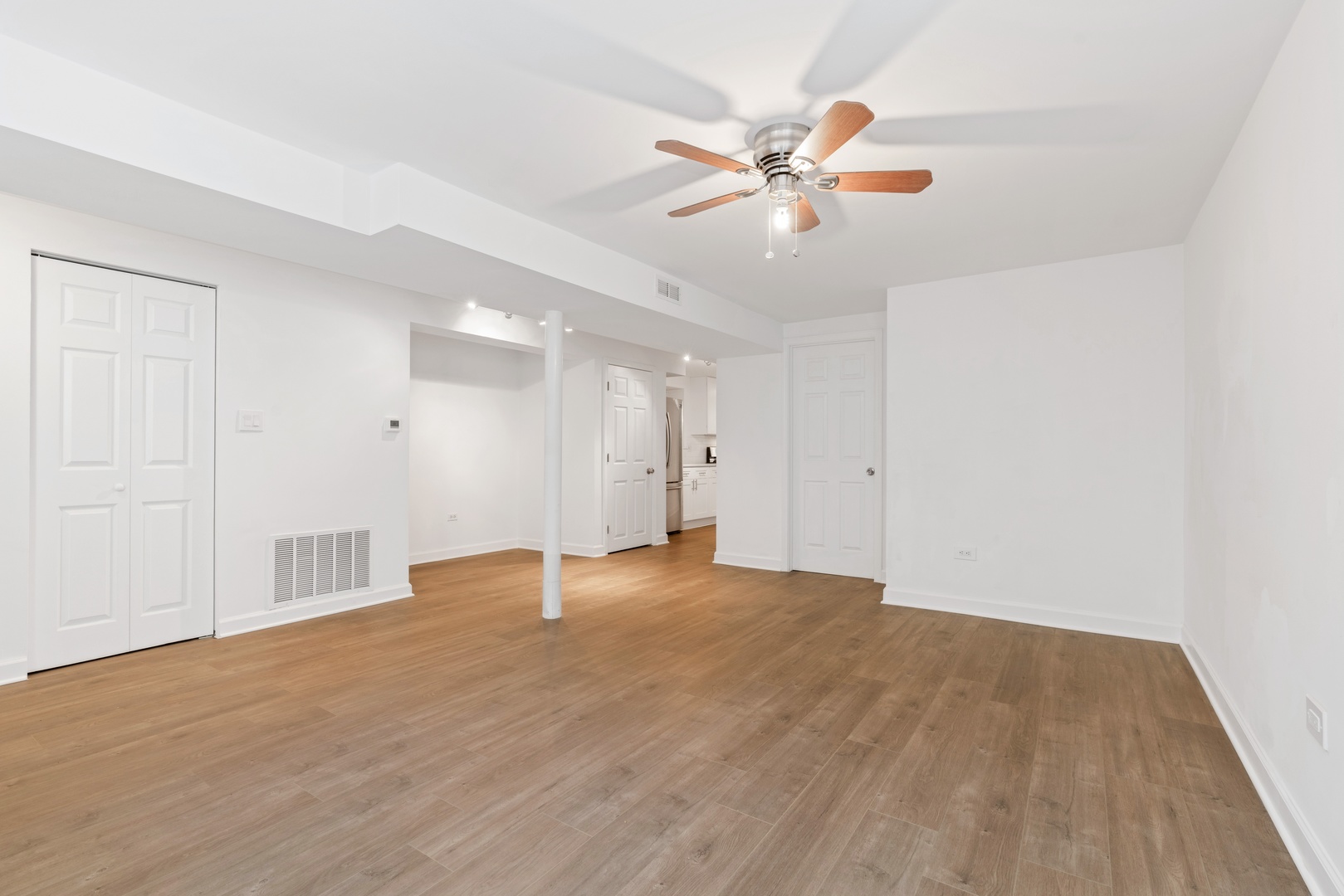 1734 West Erie Street, Unit G Chicago, IL 60622 - Photo 3 of 18 a view of an empty room with wooden floor and a chandelier fan