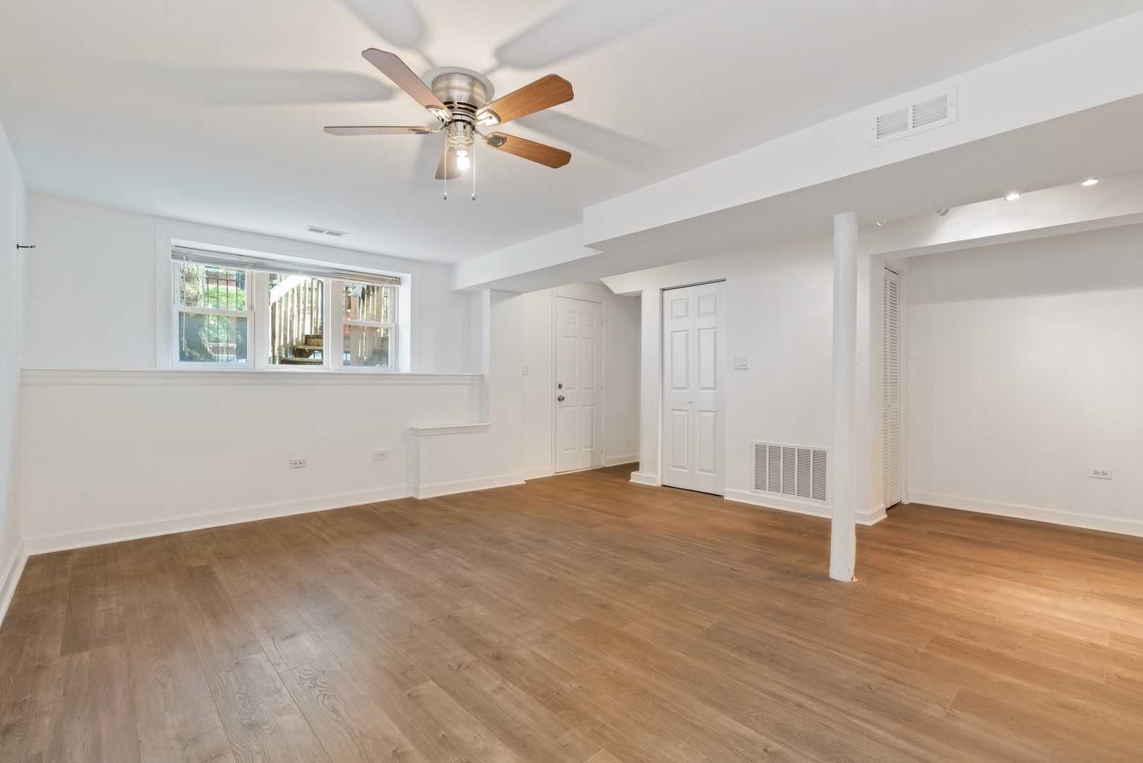1734 West Erie Street, Unit G Chicago, IL 60622 - Photo 5 of 18 a view of an empty room with wooden floor and a window