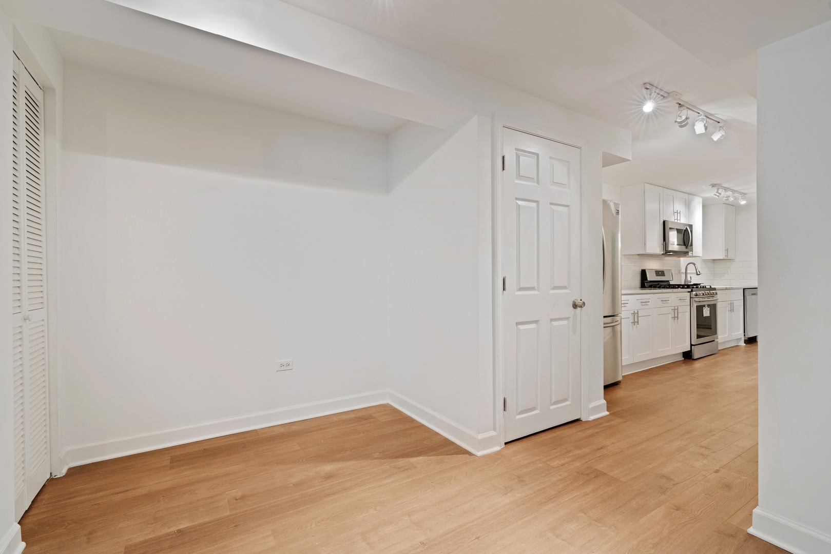 1734 West Erie Street, Unit G Chicago, IL 60622 - Photo 7 of 18 a view of a kitchen with white cabinets and stainless steel appliances