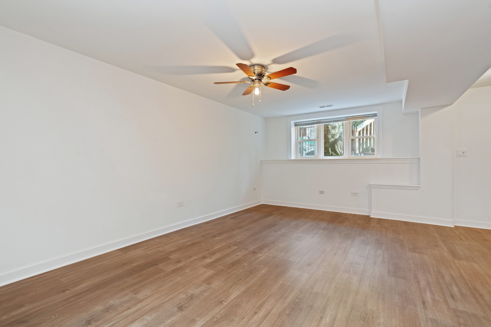 1734 West Erie Street, Unit G Chicago, IL 60622 - Photo 9 of 18 an empty room with wooden floor fan and windows