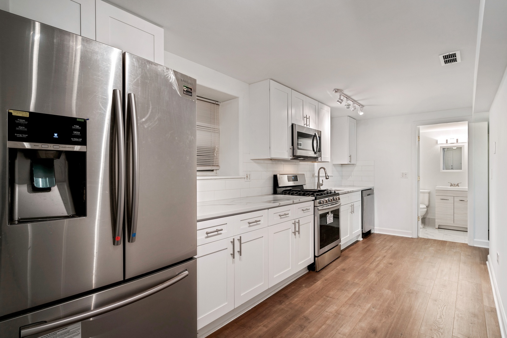 1734 West Erie Street, Unit G Chicago, IL 60622 - Photo 10 of 18 a kitchen with a refrigerator a stove top oven and wooden floor