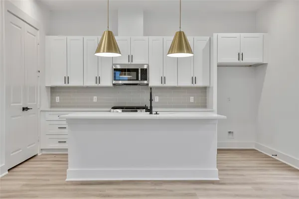 a kitchen with wooden cabinets a sink a stove and a window