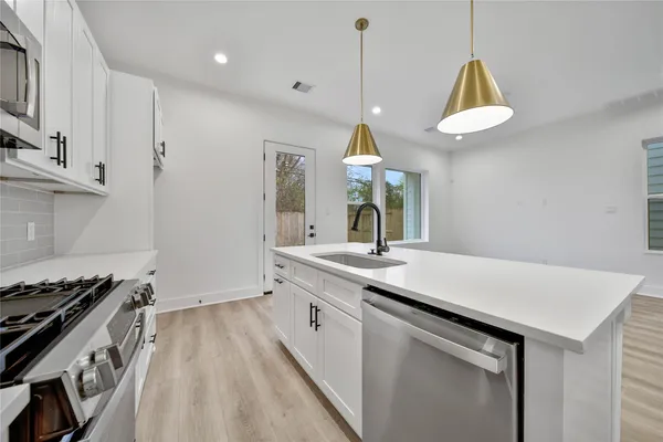 a kitchen with a sink appliances and cabinets