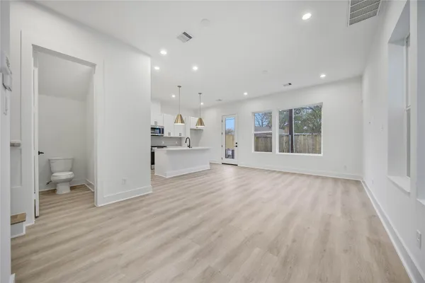 a view of empty room with wooden floor and window