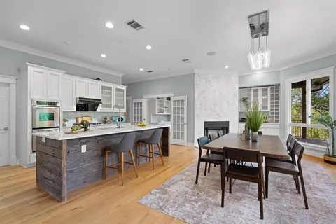 a kitchen with stainless steel appliances granite countertop a table chairs sink refrigerator and cabinets