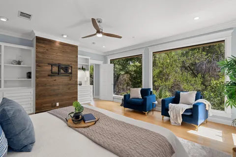 a bedroom with furniture and a large window