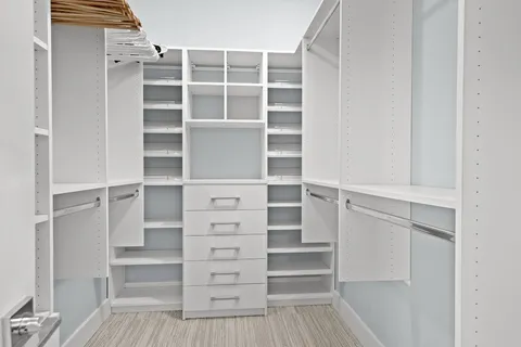 a view of walk in closet with empty racks