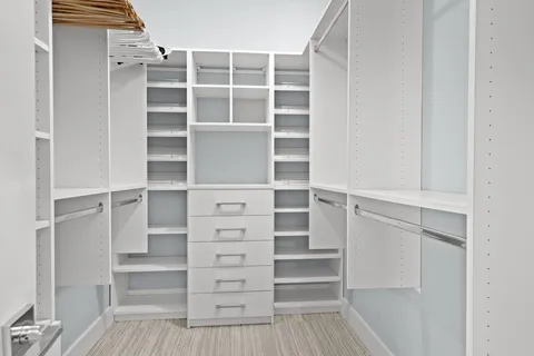 a view of walk in closet with empty racks
