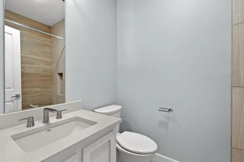 a bathroom with a sink a toilet and mirror