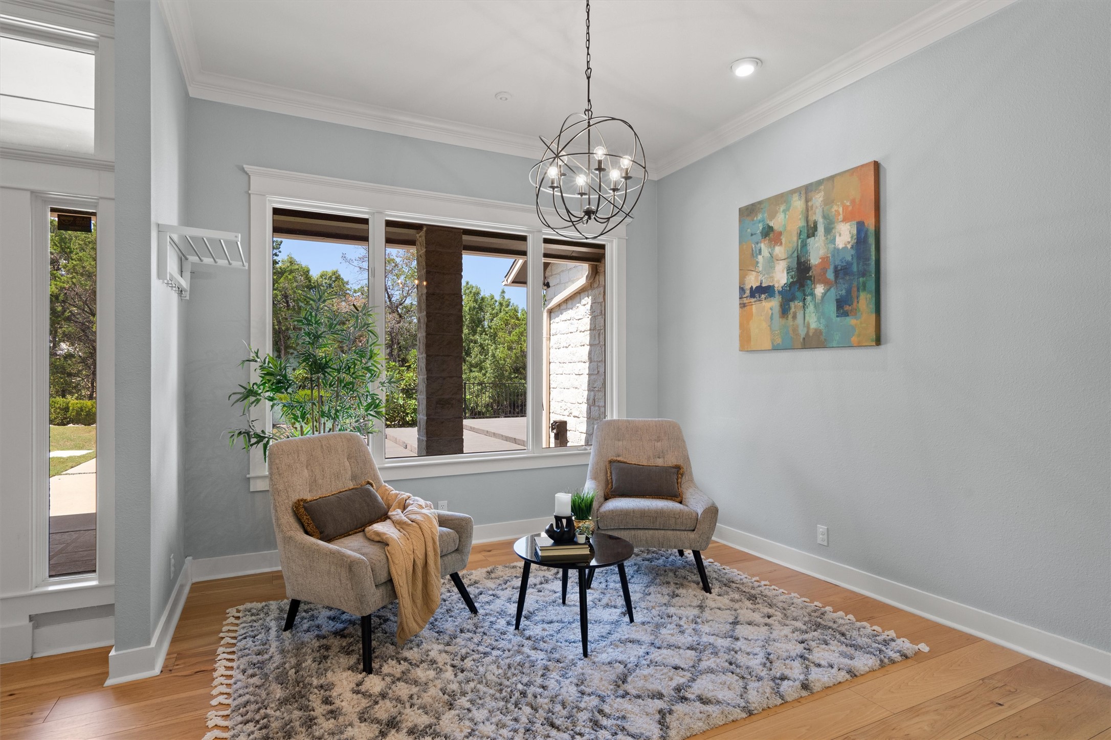 6405 Culpepper Cove Austin, TX 78730 - Photo 6 of 40 Living area featuring light wood finished floors, crown molding, and a chandelier
