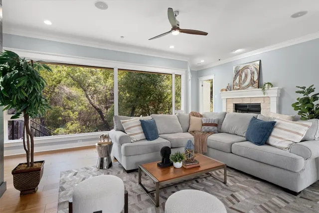 a living room with furniture fireplace and a large window