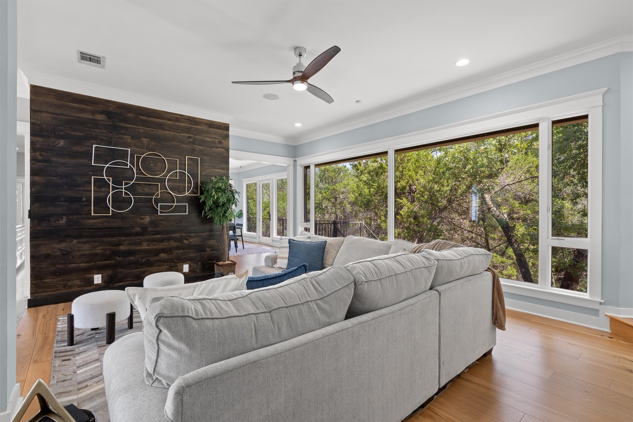 6405 Culpepper Cove Austin, TX 78730 - Photo 8 of 40 Living room featuring crown molding, light wood finished floors, ceiling fan, wooden walls, and recessed lighting