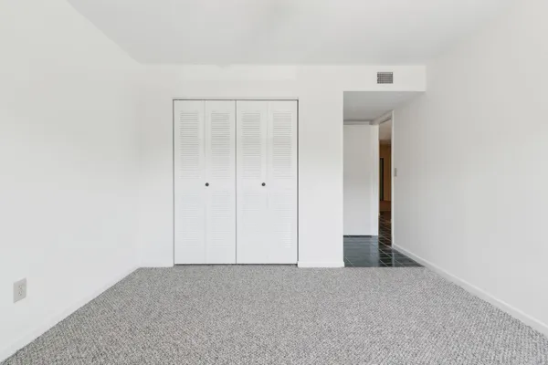 an empty room with a ceiling fan and a window
