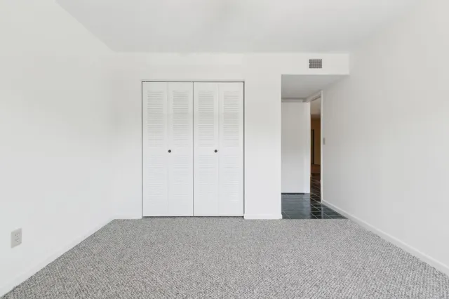 an empty room with a ceiling fan and a window