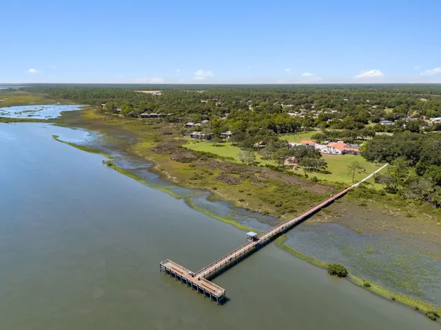 an aerial view of residential houses with outdoor space and ocean view