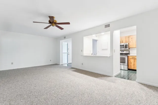 a view of empty room with wooden floor and windows