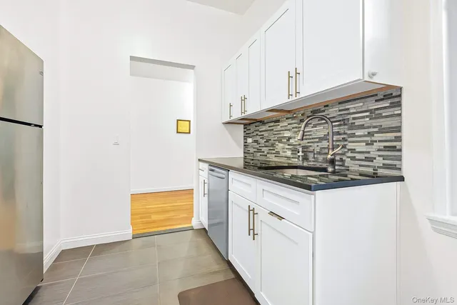 a kitchen with white cabinets and a sink