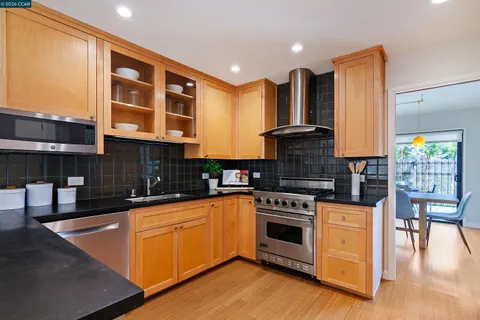 a kitchen with stainless steel appliances granite countertop a stove a sink and a microwave