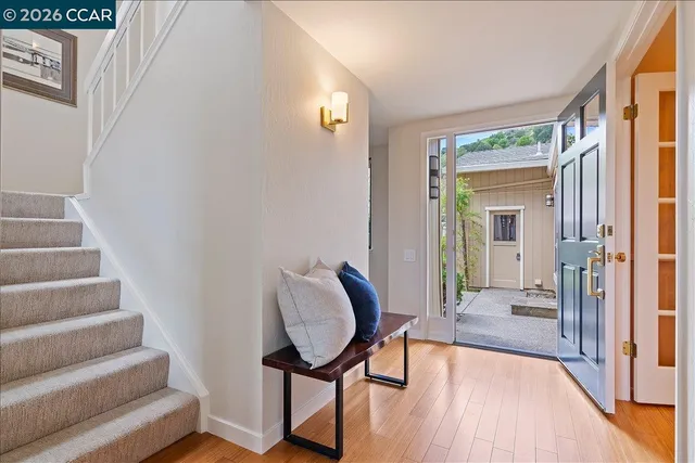 a view of a hallway with wooden floor and furniture