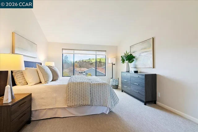 a bedroom with a large bed and wooden floor
