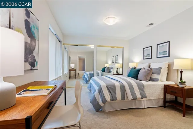 a spacious bedroom with a bed and lamp