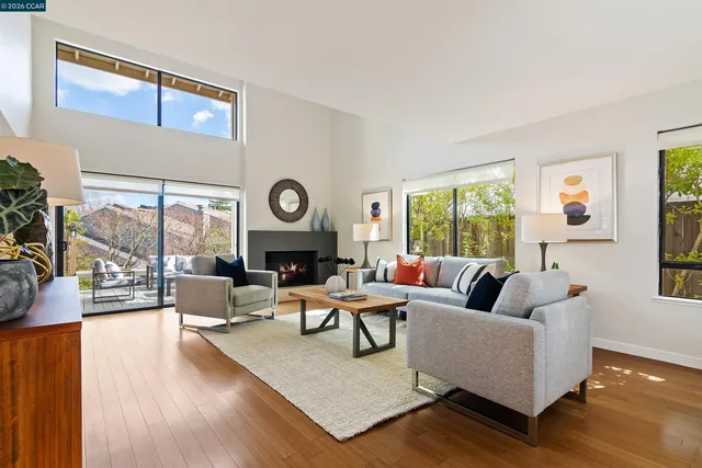 a living room with fireplace furniture and a large window