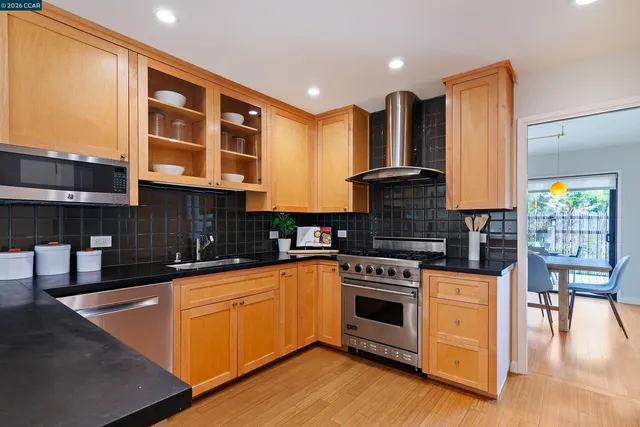a kitchen with stainless steel appliances granite countertop a stove a sink and a microwave