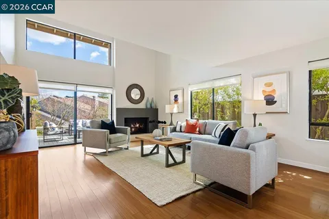 a living room with fireplace furniture and a large window
