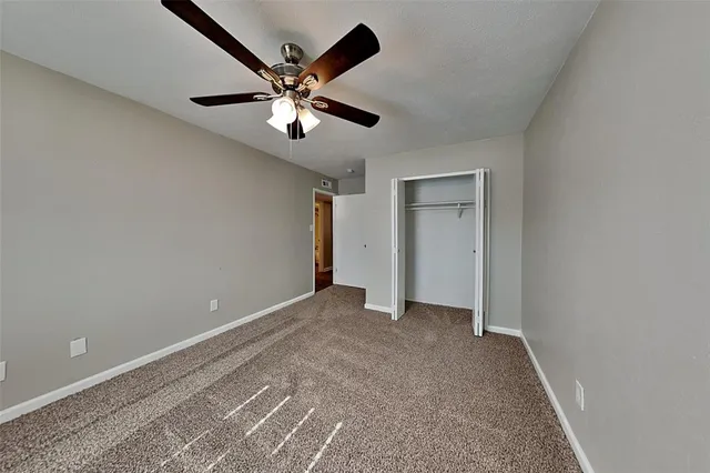 a view of an empty room with a ceiling fan