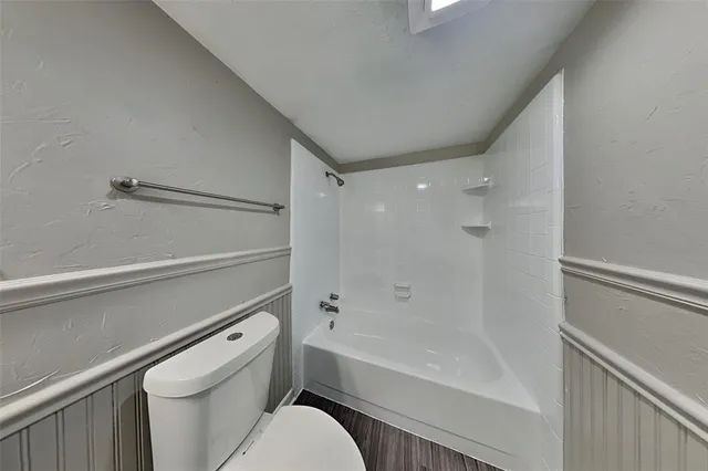 a bathroom with a granite countertop toilet a sink and bathtub