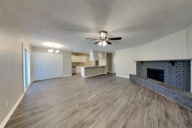a view of a livingroom with a fireplace a sink and dishwasher cabinets