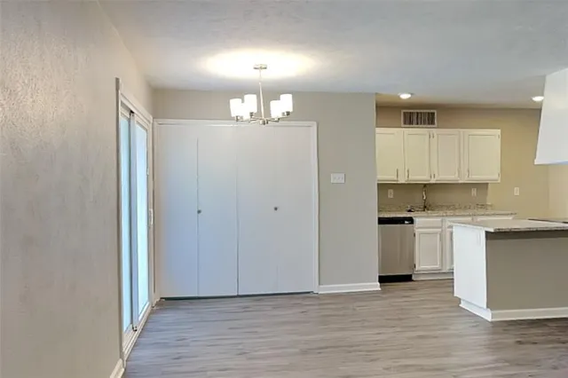 a view of a kitchen with a sink and dishwasher a refrigerator with wooden floor