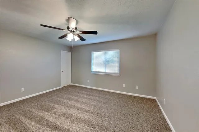 a view of a room with a ceiling fan and a window
