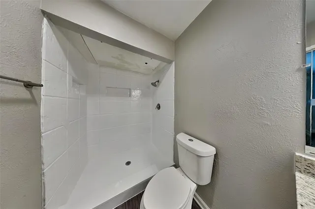 a white toilet sitting next to a shower