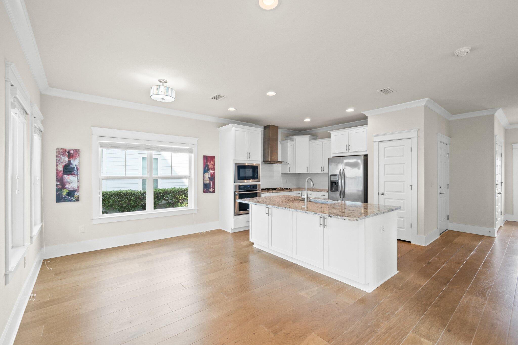89 Grande Pointe Drive Inlet Beach, FL 32461 - Photo 16 of 47 a large white kitchen with stainless steel appliances kitchen island a large counter top and a wooden floors