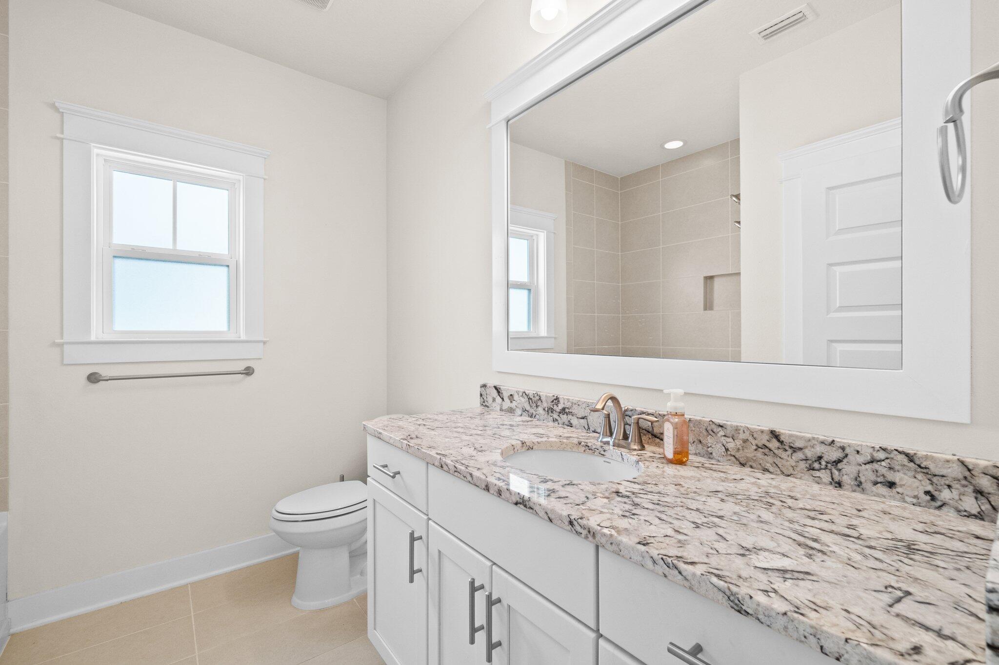 89 Grande Pointe Drive Inlet Beach, FL 32461 - Photo 22 of 47 a bathroom with a granite countertop sink a toilet and a window