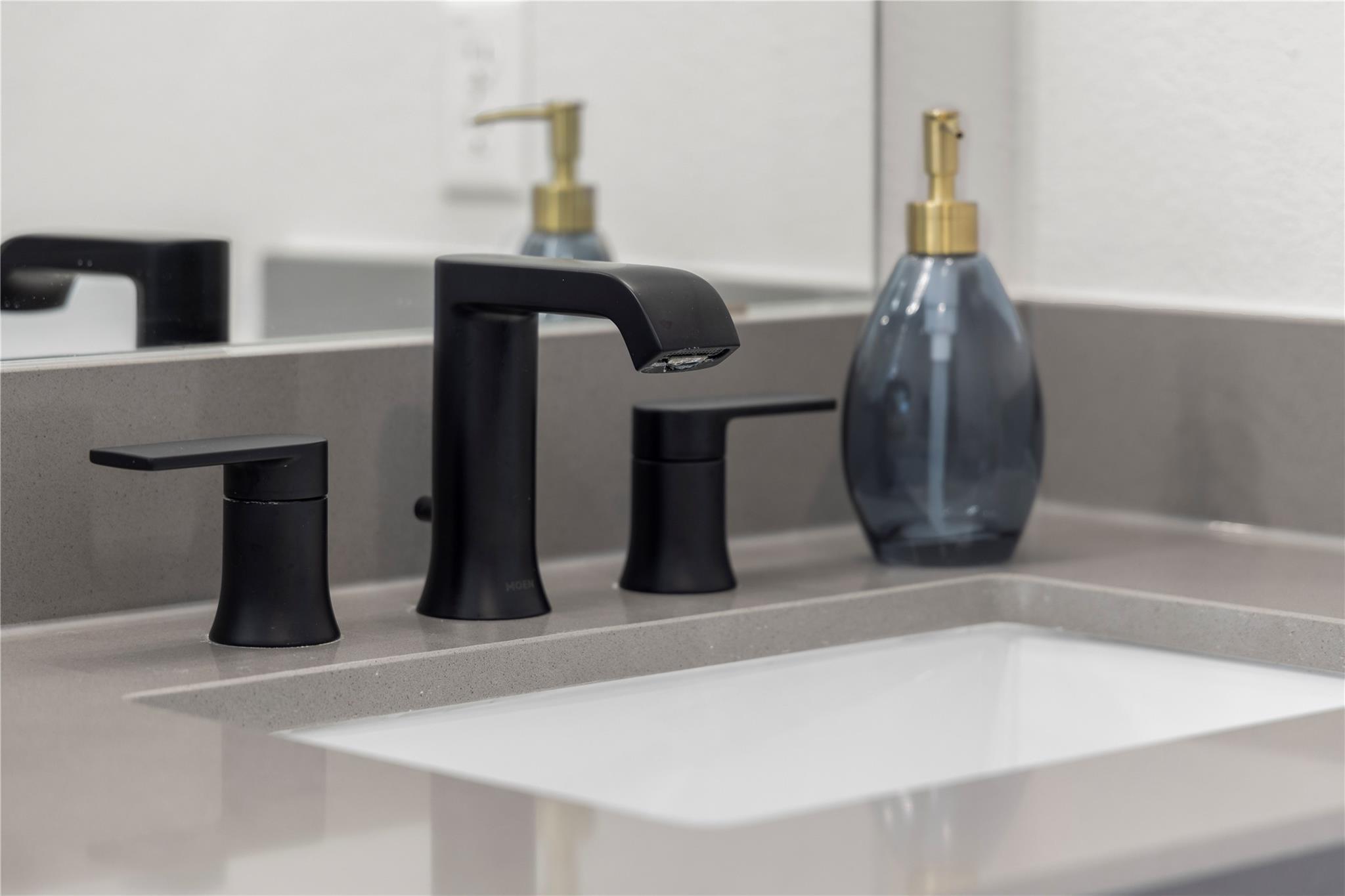 1128 Villa Rialto View Leander, TX 78641 - Photo 34 of 40 A well-appointed bathroom vanity features sleek matte black fixtures and a pristine white sink.