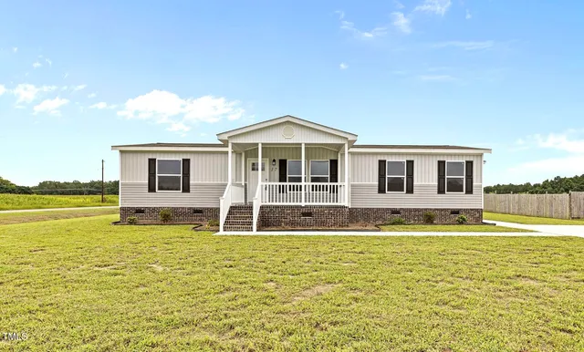 a large pool that has lawn chairs near an ocean