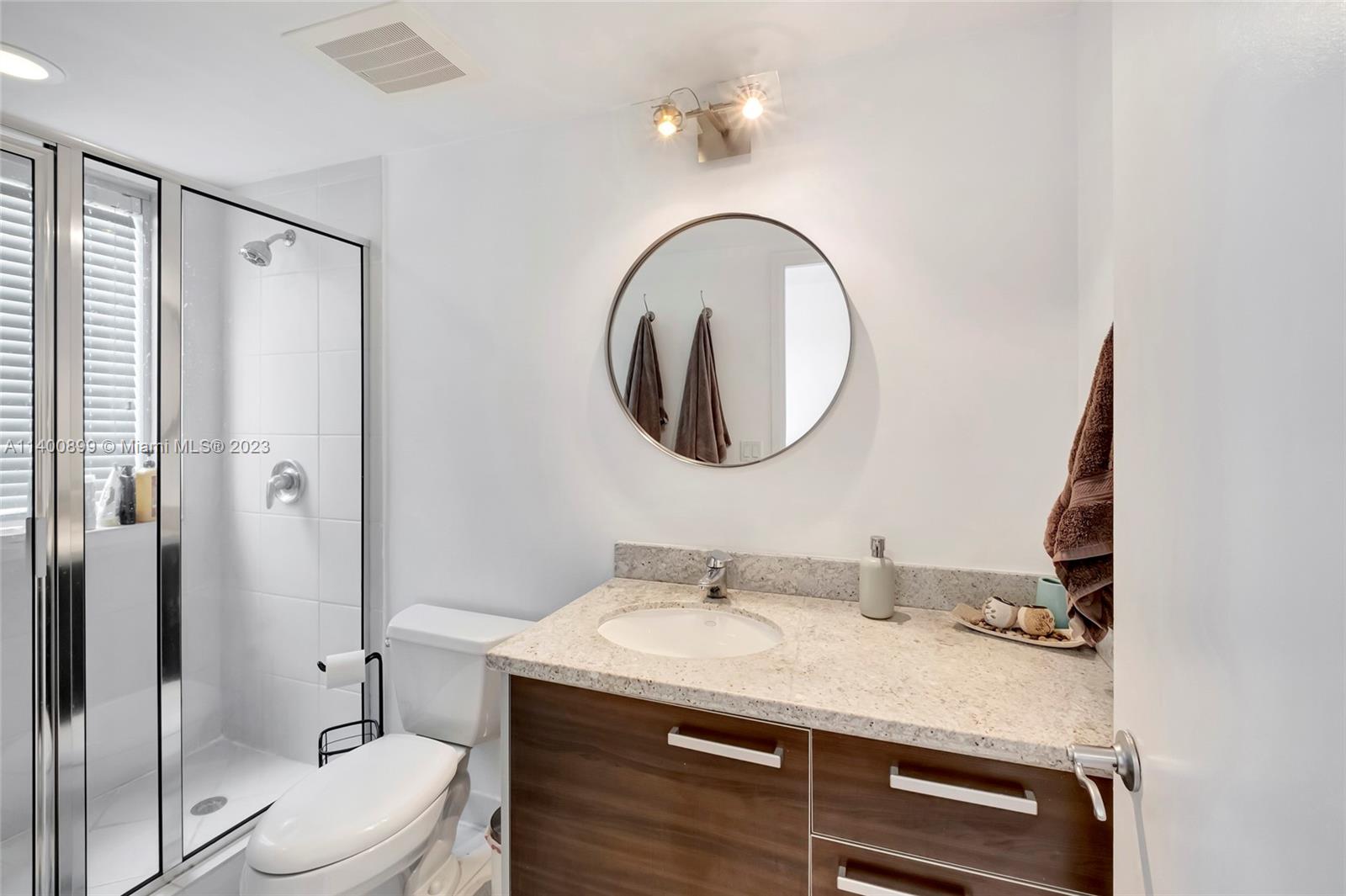 185 Southwest 7th Street, Unit 901 Miami, FL 33130 - Photo 15 of 35 a bathroom with a granite countertop sink mirror vanity and toilet