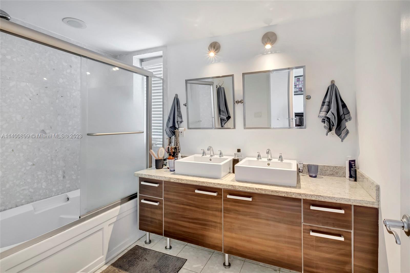 185 Southwest 7th Street, Unit 901 Miami, FL 33130 - Photo 19 of 35 a bathroom with a sink double vanity granite tub shower and a mirror