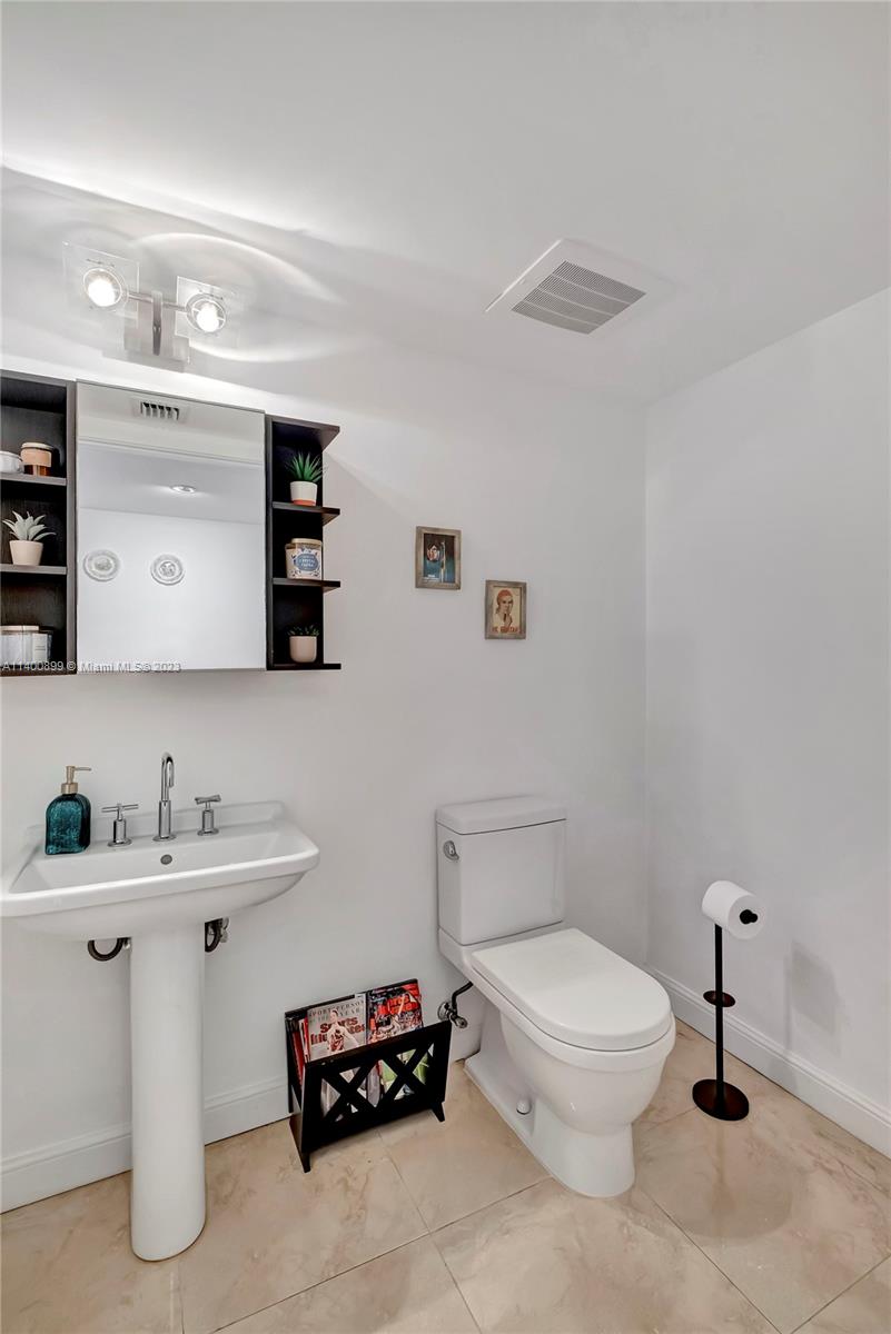 185 Southwest 7th Street, Unit 901 Miami, FL 33130 - Photo 4 of 35 a bathroom with a toilet sink and mirror