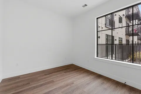 a view of an empty room with wooden floor