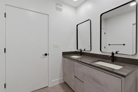 a bathroom with a granite countertop sink a toilet and a mirror