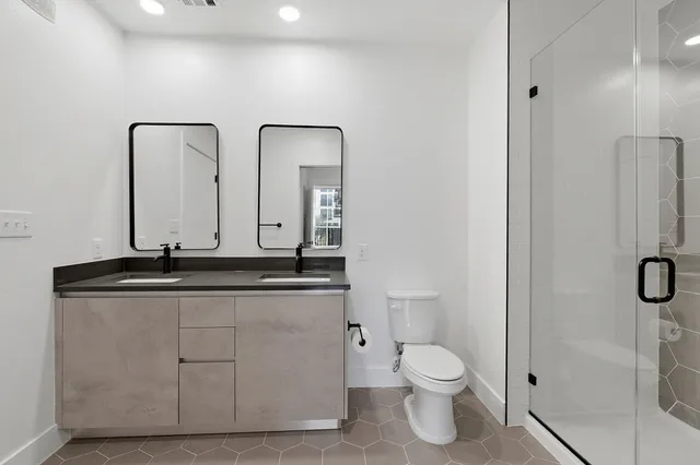 a bathroom with a granite countertop sink a toilet and a mirror