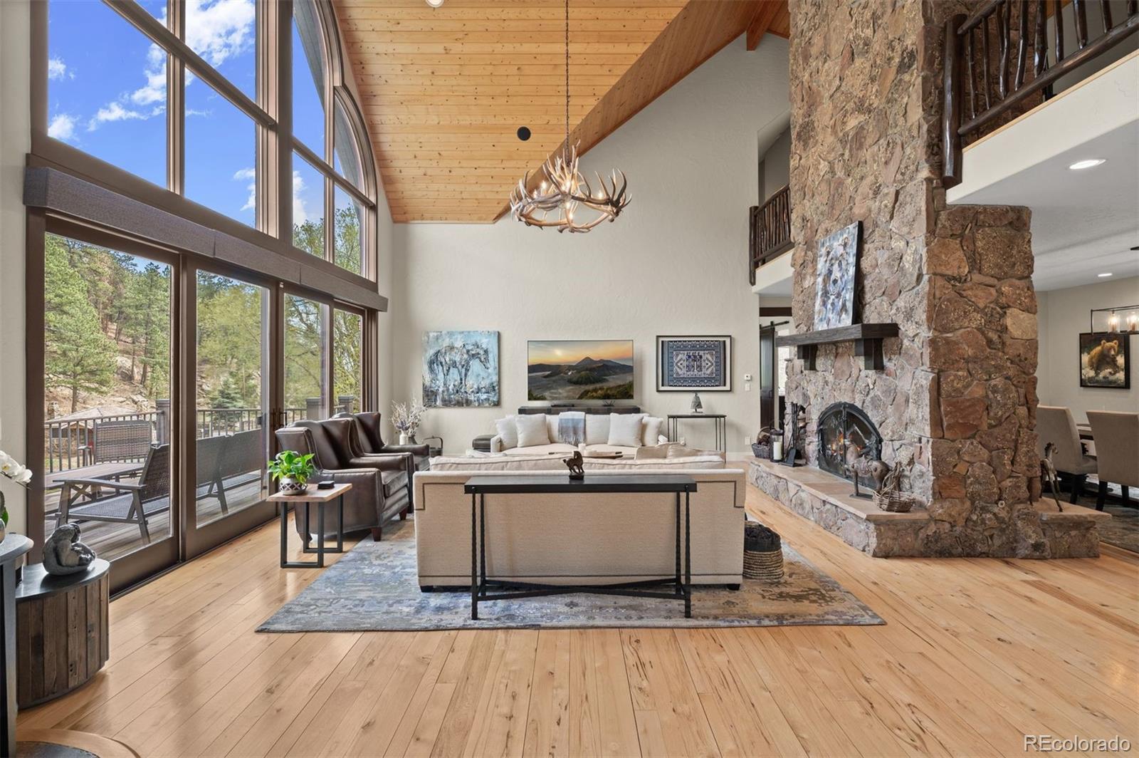 1733 Swede Gulch Road Evergreen, CO 80439 - Photo 11 of 50 a living room with furniture a fireplace and a table