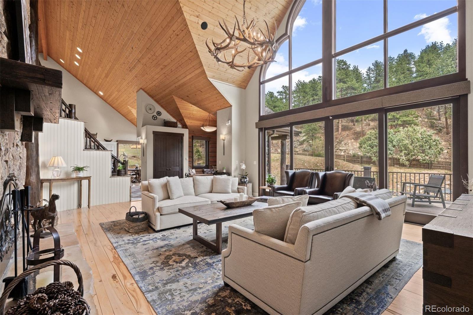 1733 Swede Gulch Road Evergreen, CO 80439 - Photo 13 of 50 a living room with furniture large windows and wooden floor