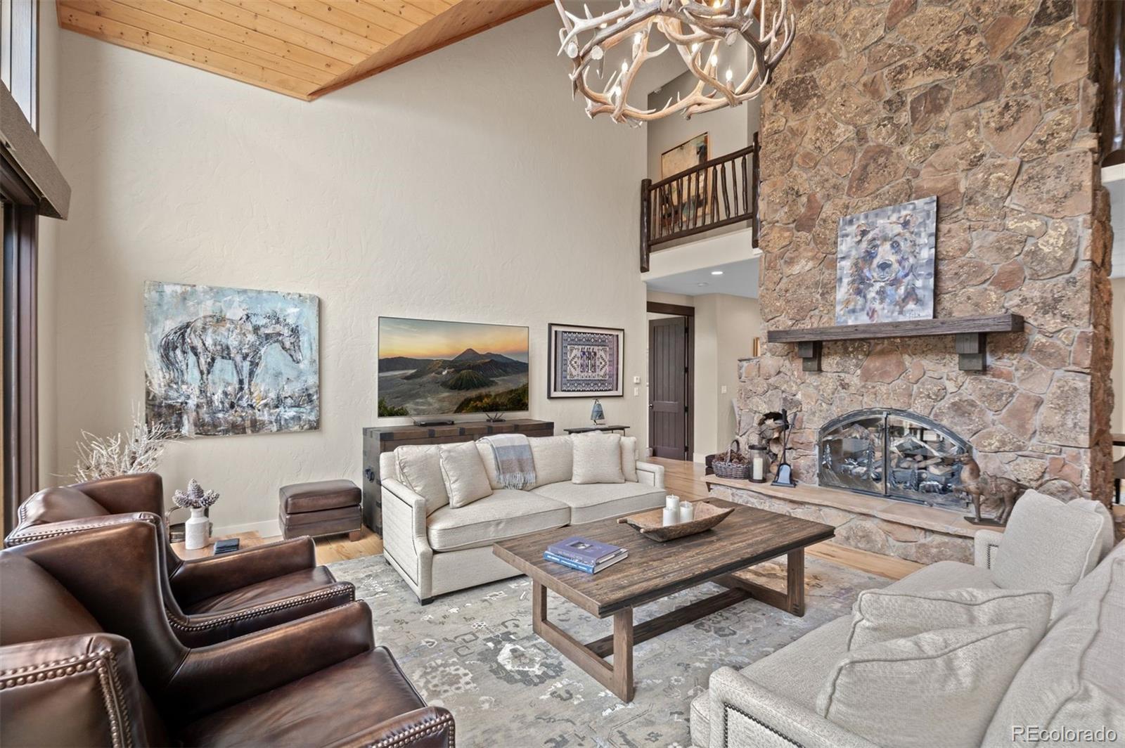1733 Swede Gulch Road Evergreen, CO 80439 - Photo 14 of 50 a living room with furniture a table and a fireplace