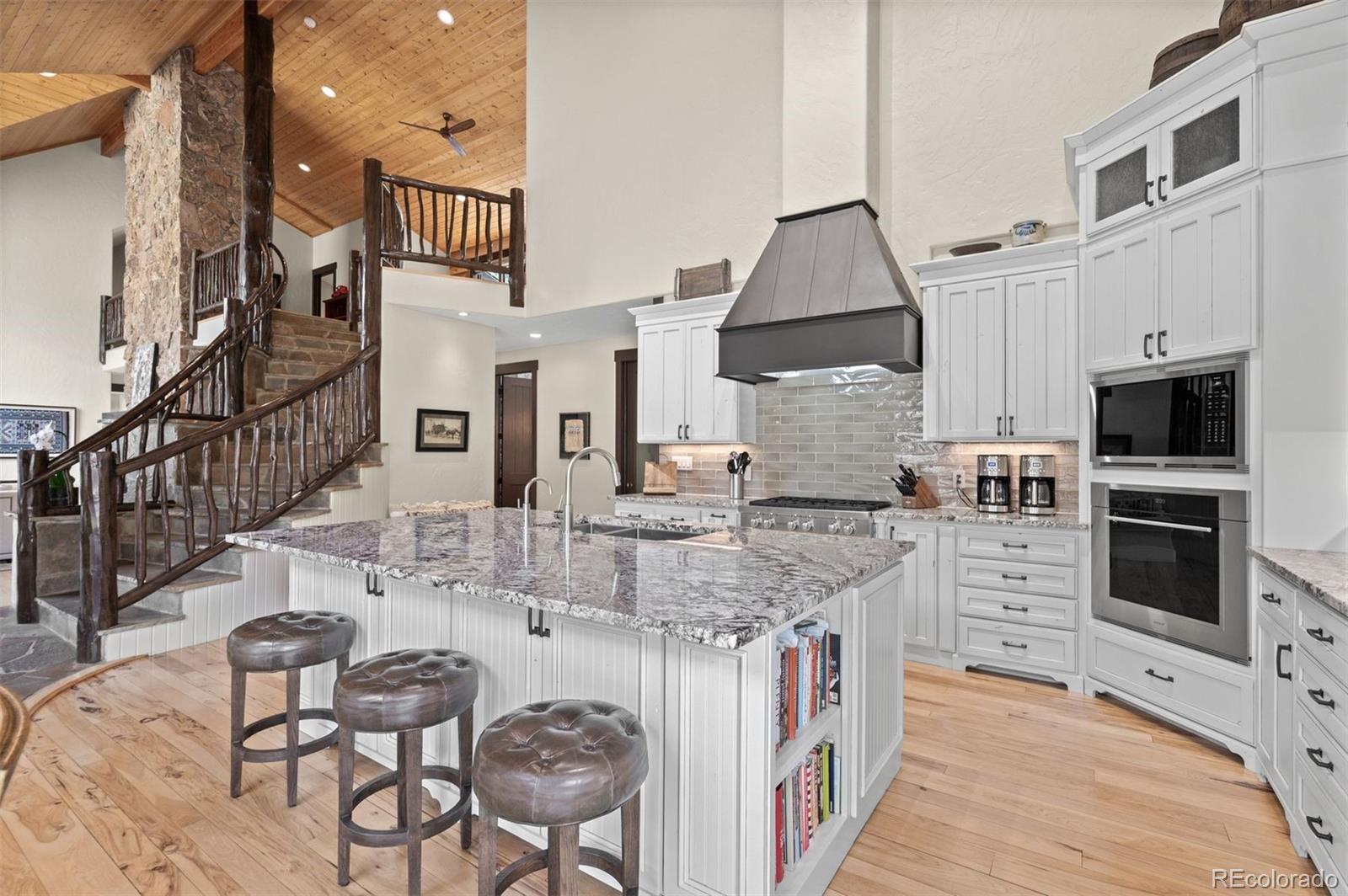 1733 Swede Gulch Road Evergreen, CO 80439 - Photo 21 of 50 a kitchen with stainless steel appliances granite countertop a stove top oven a sink a counter space and cabinets