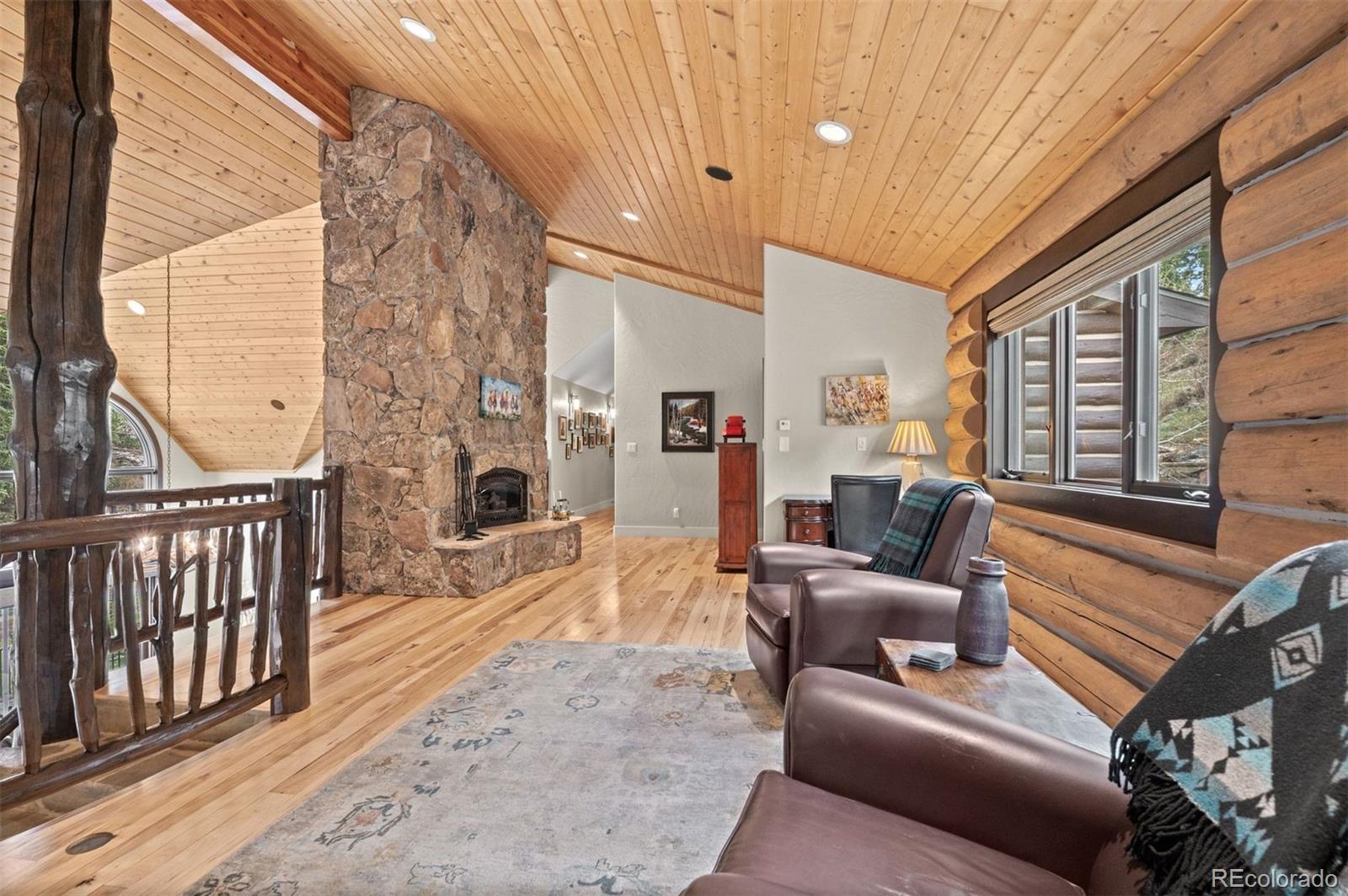 1733 Swede Gulch Road Evergreen, CO 80439 - Photo 29 of 50 a living room with furniture a fireplace and a flat screen tv