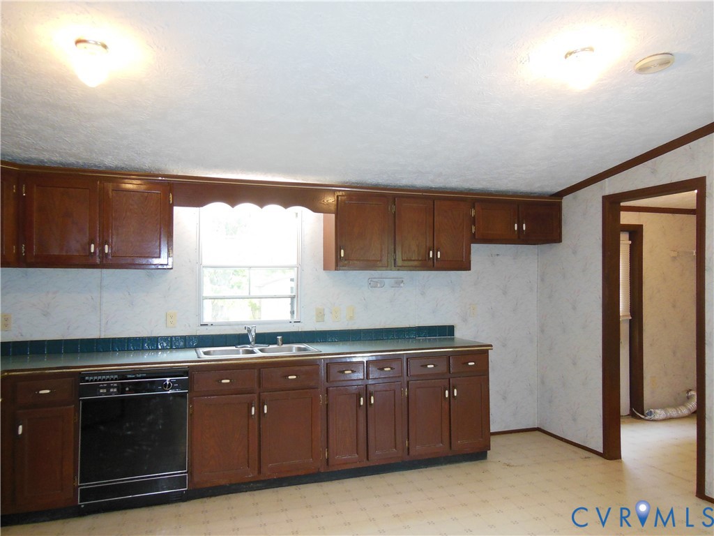 5018 Olgers Road Sutherland, VA 23885 - Photo 13 of 26 a kitchen with stainless steel appliances granite countertop a stove a sink and a refrigerator with wooden cabinets